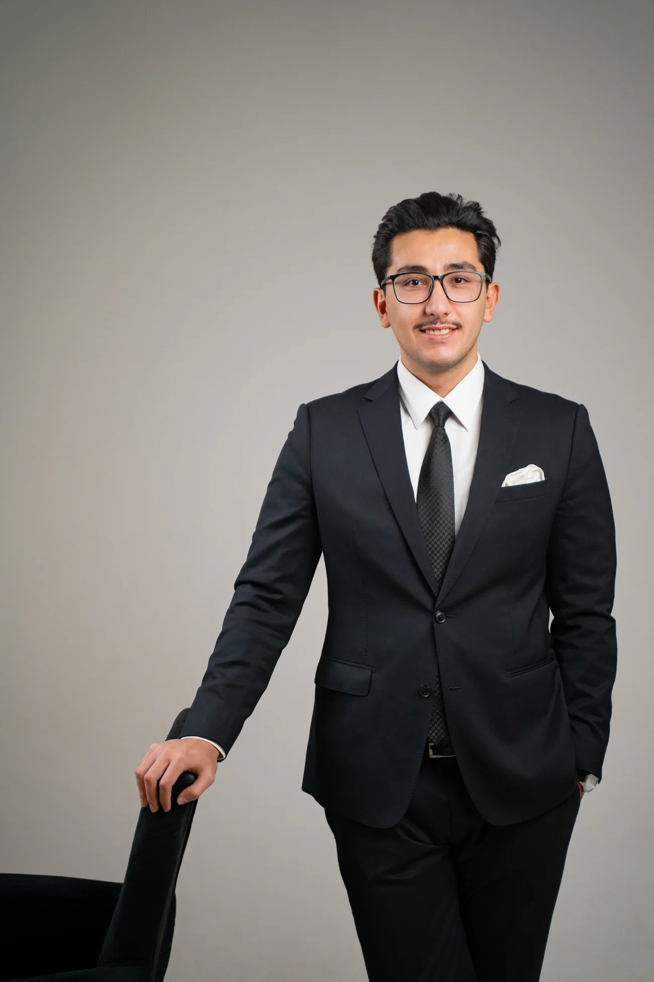 Shokhrukh Kudratov, founder of Polyglot, smiling in a dark suit